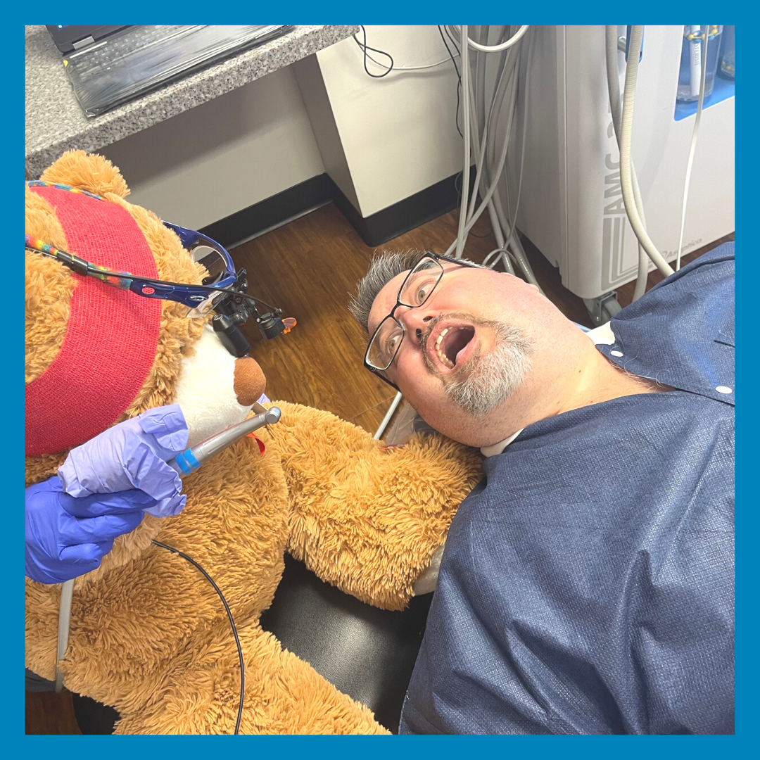Bennie the bear gives Dr. Clark a dental cleaning during their visit during National Teddy Bear Day.